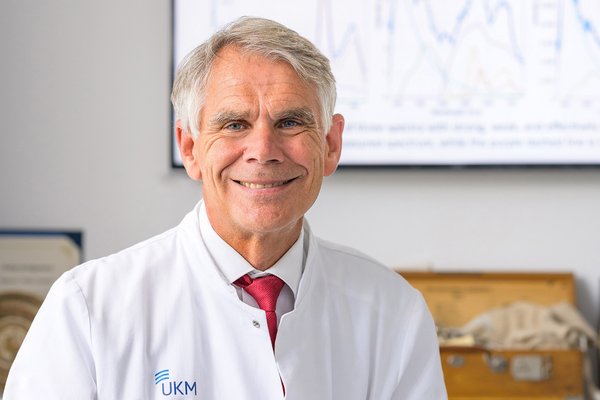 UKM | Neurochirurg Walter Stummer im weißen Kittel in seinem Büro