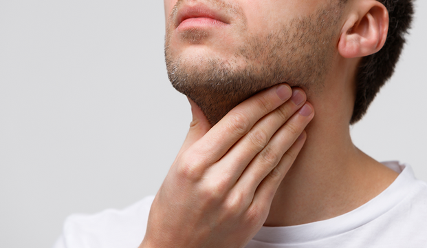 UKM Phoniatrie | Ausschnitt: Untere Gesichtspartie eines Mannes, der sich mit der Hand an den Hals fasst