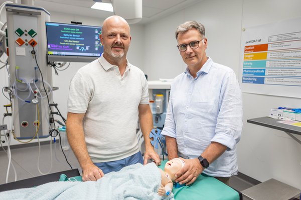 UKM | Pressemitteilung | Die beiden Leiter mit einer Babypuppe in einem Übungsraum mit Geräten