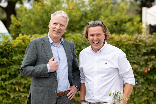 Christoph Hoppenheit, Andreas Rütz lachend vor einer Hecke