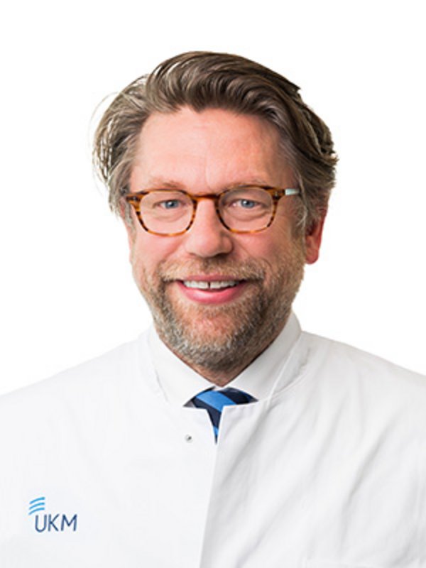 UKM Plastische Chirurgie | Tobias Hirsch | Mann mit Brille lächelt in die Kamera.