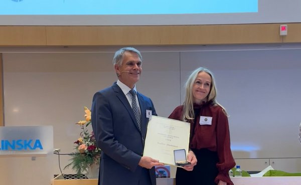 UKM | Der mit dem Olivecrona Award ausgezeichnete Neurochirurg hält die Urkunde und die Medaille in den Händen. Daneben steht die Präsidentin der Schwedischen Gesellschaft für Neurochirurgie.