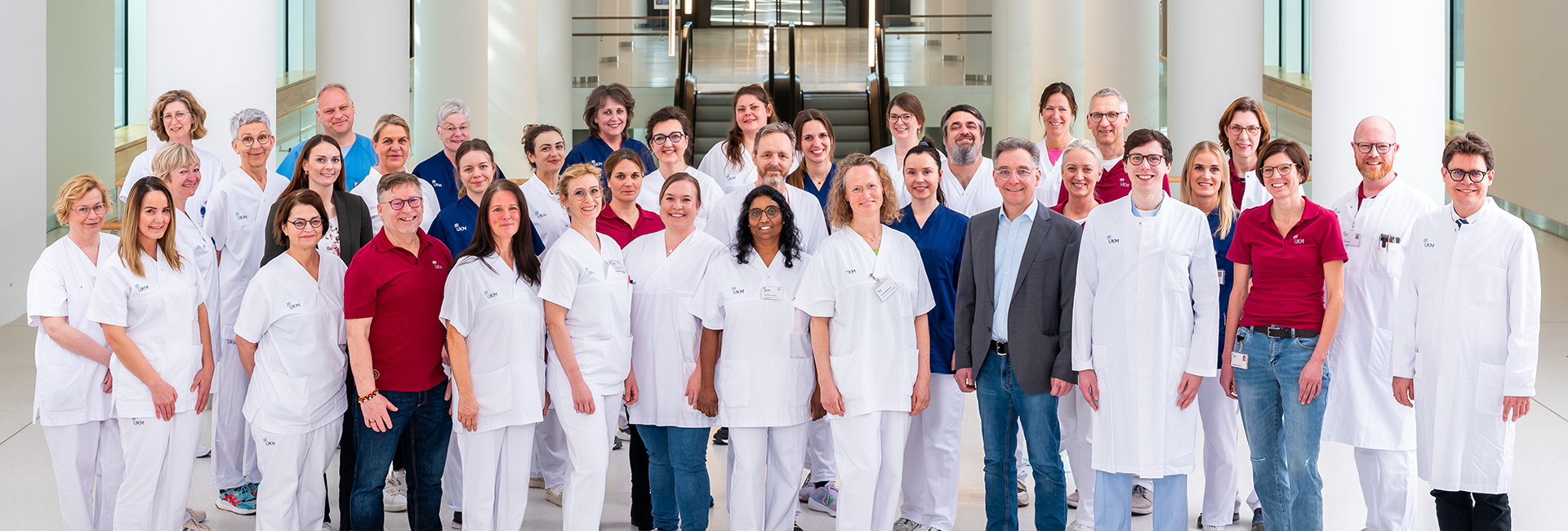 UKM | Das komplette Team der Palliativmedizin, viele Männer und Frauen, zum Teil in weißen Kitteln und Kasacks